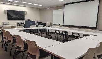 Allen large seminar room with projector, display screen, podium, keyboard, and seating